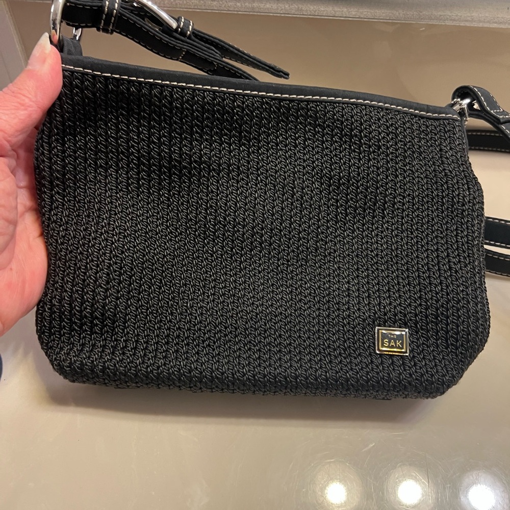 The Sak black woven shoulder or crossbody with Sak bag charm
